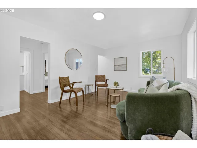 a living room with furniture a dining table and a potted plant