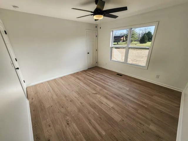 wooden floor in an empty room with a window