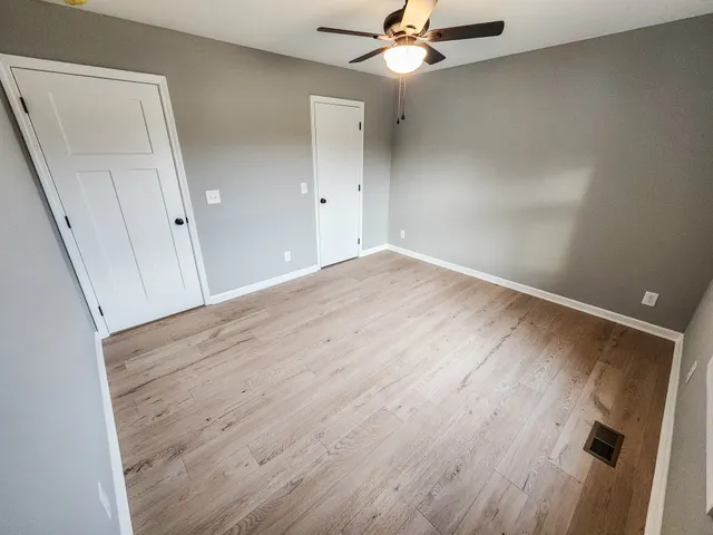 an empty room with wooden floor and door