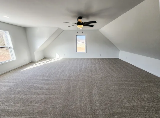 an empty room with windows and ceiling fan