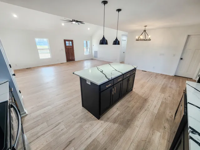 a kitchen with a stove and a wooden floor