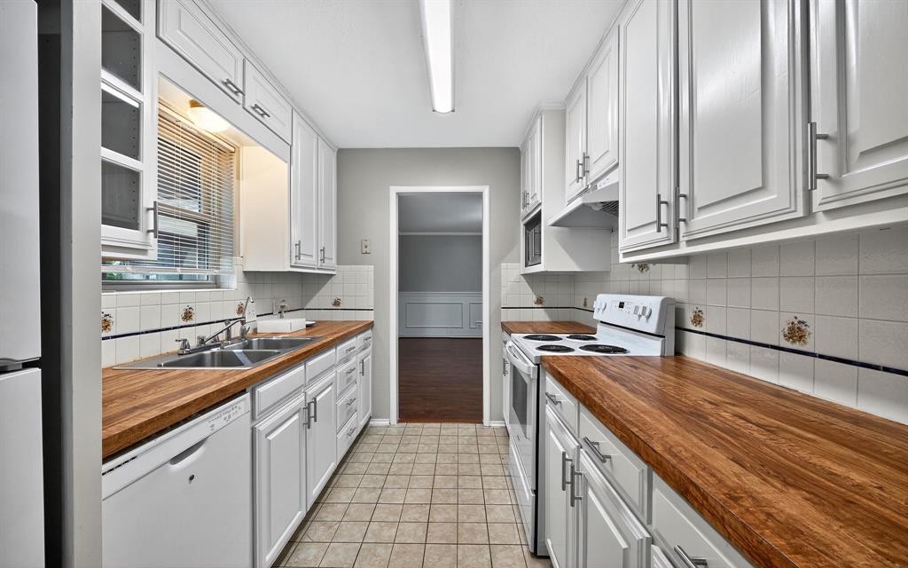 220 Short Street Burleson, TX 76028 - Photo 15 of 36 a kitchen with stainless steel appliances granite countertop a sink stove and refrigerator