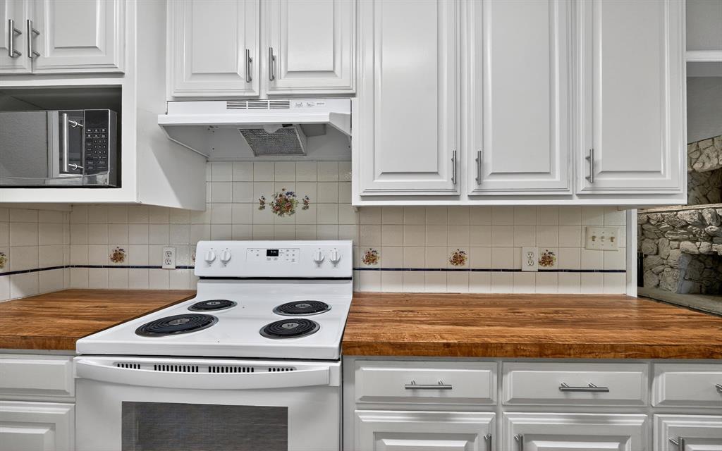 220 Short Street Burleson, TX 76028 - Photo 18 of 36 a kitchen with granite countertop a stove sink and cabinets