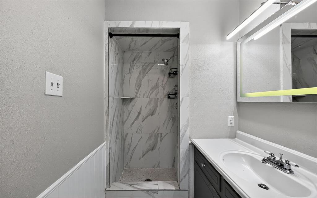 220 Short Street Burleson, TX 76028 - Photo 21 of 36 a bathroom with a granite countertop sink a mirror and shower