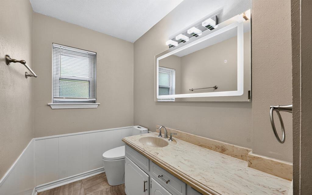 220 Short Street Burleson, TX 76028 - Photo 22 of 36 a bathroom with a granite countertop sink toilet and mirror