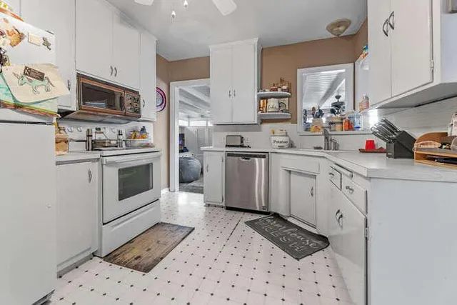 a kitchen with stainless steel appliances a sink stove refrigerator and cabinets