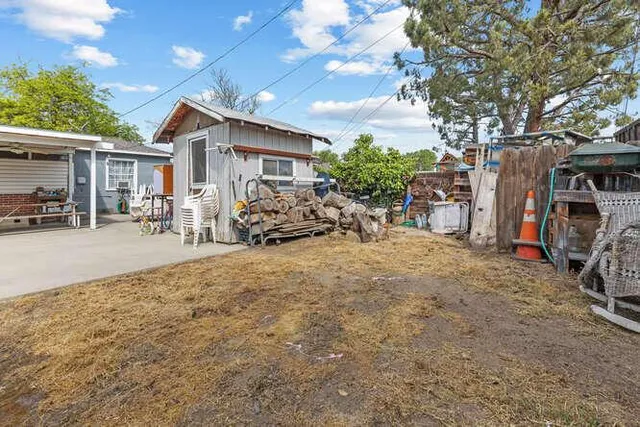 a view of a house with backyard and sitting area