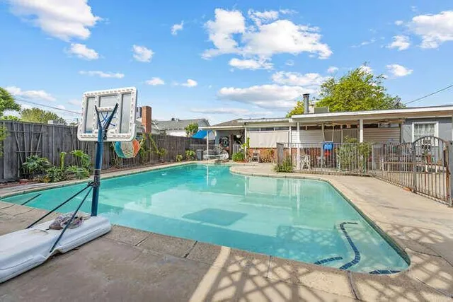 a view of a house with a swimming pool and sitting area