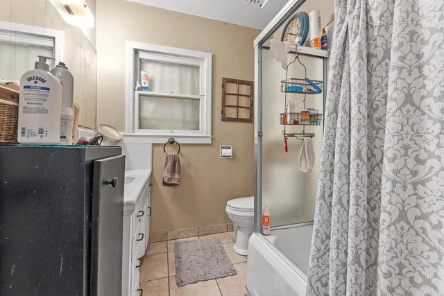 a bathroom with sink a mirror a toilet and shower
