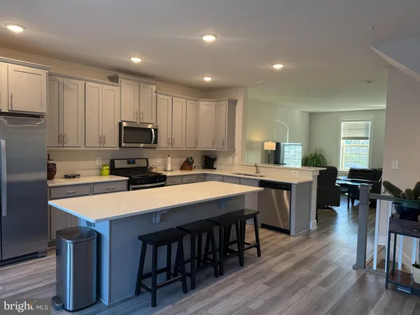 a large kitchen with kitchen island a sink table and chairs