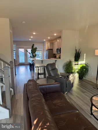 a living room with furniture kitchen view and a potted plant