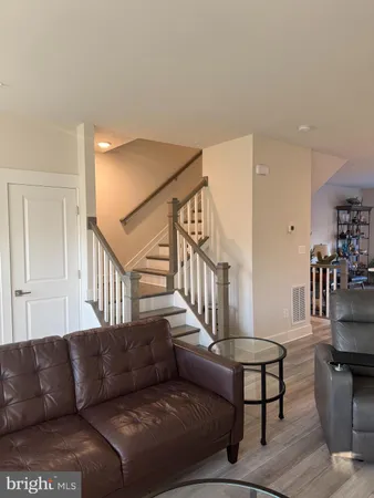 a living room with furniture and a dining table with wooden floor