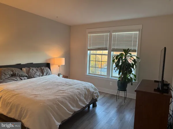 a bedroom with a bed potted plant with the window