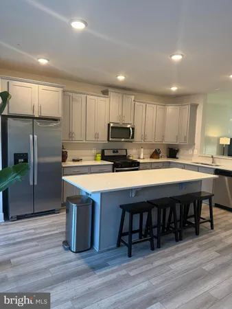 a kitchen with stainless steel appliances granite countertop a table chairs refrigerator microwave and cabinets