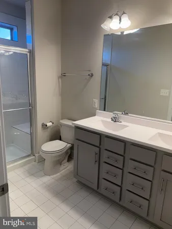 a bathroom with a double vanity sink mirror and toilet
