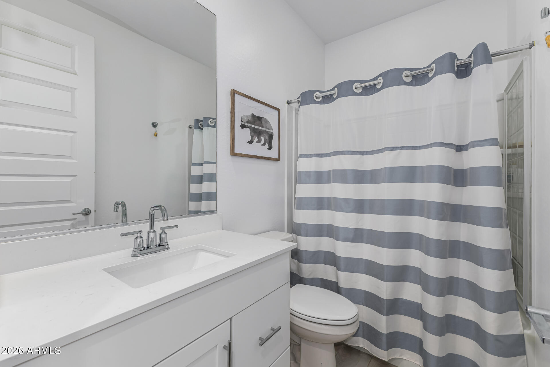 3347 South 156th Avenue Goodyear, AZ 85338 - Photo 32 of 50 a bathroom with a sink toilet a mirror and shower curtain
