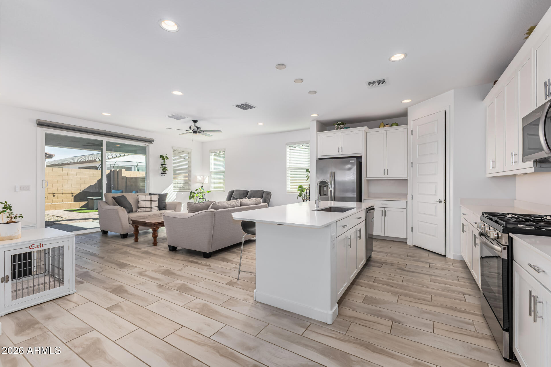 3347 South 156th Avenue Goodyear, AZ 85338 - Photo 3 of 50 a large kitchen with kitchen island a large counter space a sink a stove and a center island