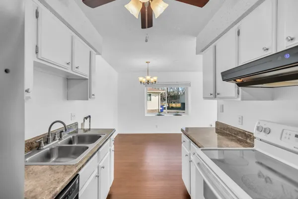 a view of a hallway with wooden floor and windows