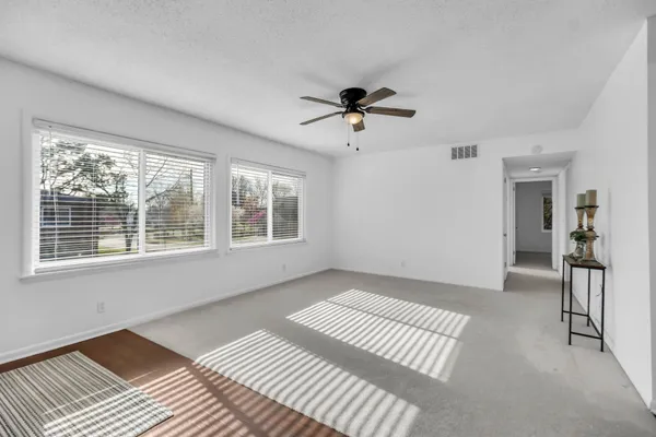 an empty room with a window and a ceiling fan