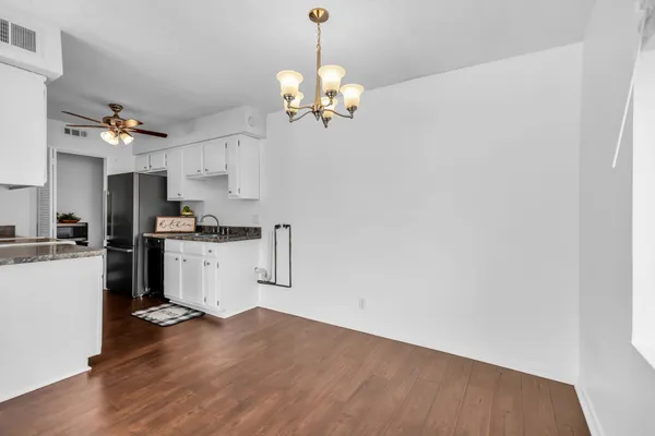 a kitchen with granite countertop a stove a sink and a refrigerator