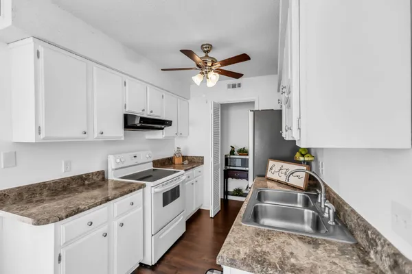 a kitchen with stainless steel appliances granite countertop a sink a stove and refrigerator