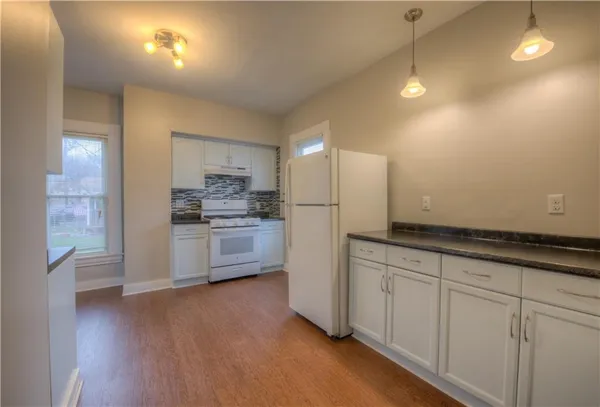a kitchen with granite countertop white cabinets and stainless steel appliances
