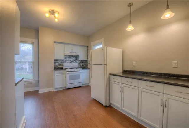 a kitchen with granite countertop white cabinets and stainless steel appliances
