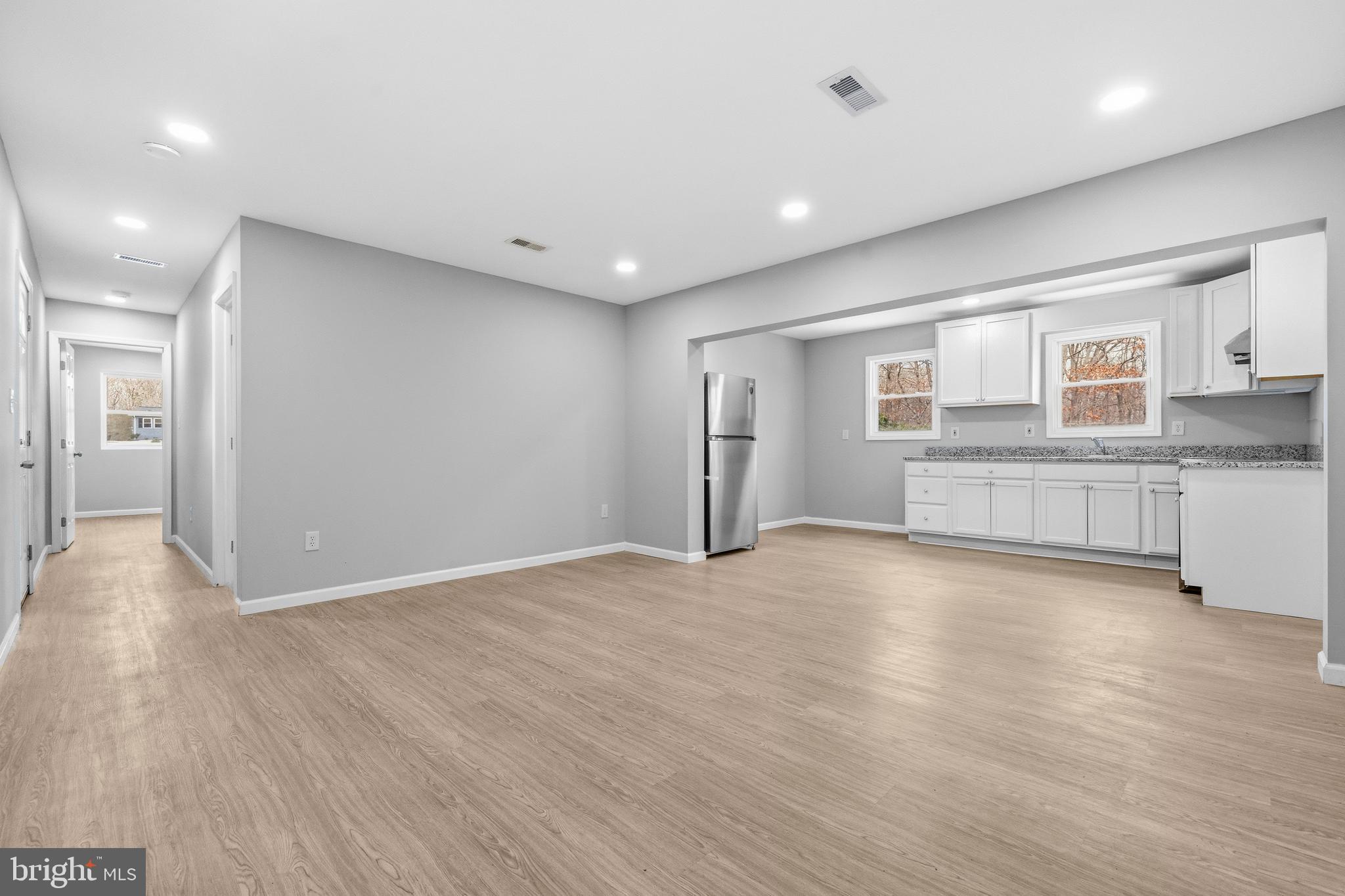 3720 Mt Pleasant Road Waldorf, MD 20601 - Photo 10 of 31 a view of an empty room with wooden floor and a kitchen