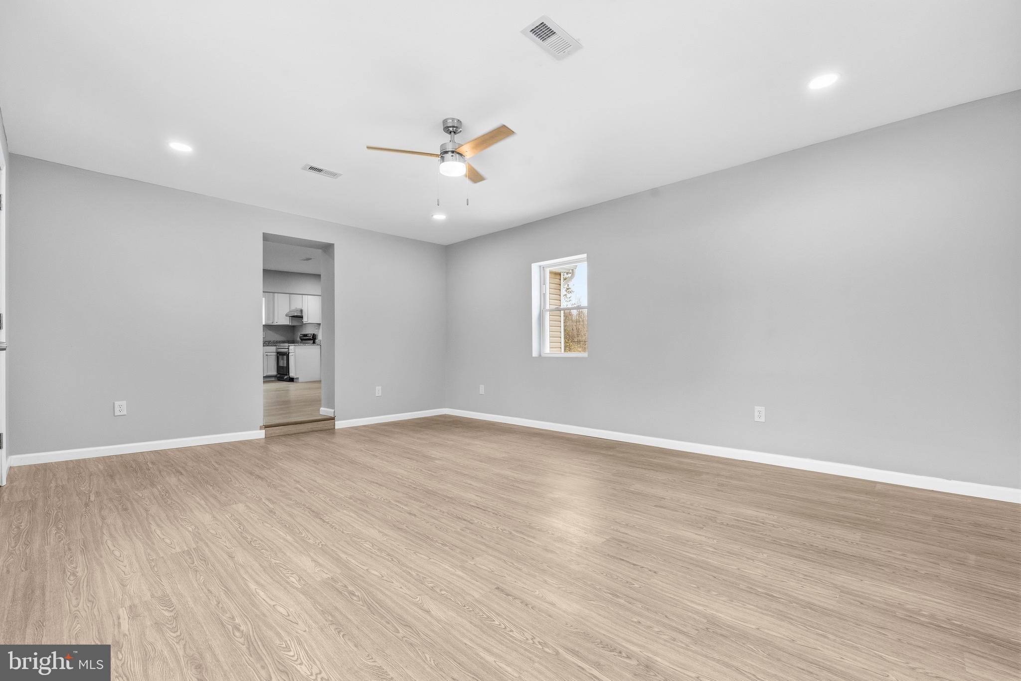 3720 Mt Pleasant Road Waldorf, MD 20601 - Photo 8 of 31 an empty room with wooden floor chandelier fan and windows