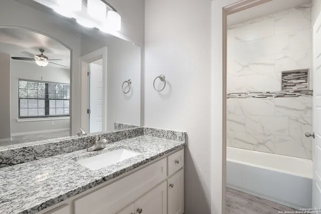 a bathroom with a granite countertop sink and a mirror