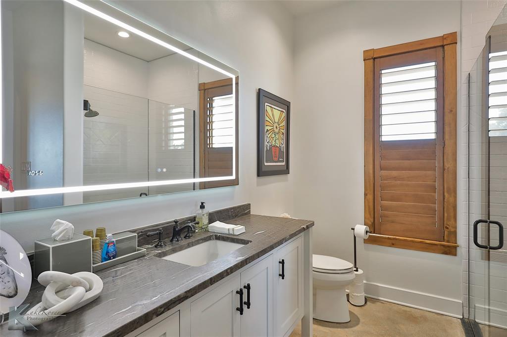 226 Rabbit Run Tuscola, TX 79562 - Photo 19 of 40 a bathroom with a granite countertop toilet sink and mirror