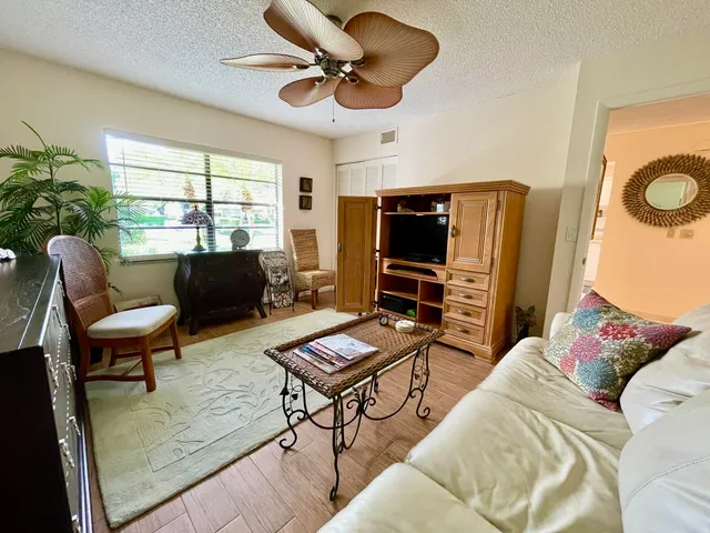 a living room with furniture a flat screen tv and a window