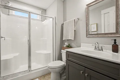 a bathroom with a sink a toilet and shower