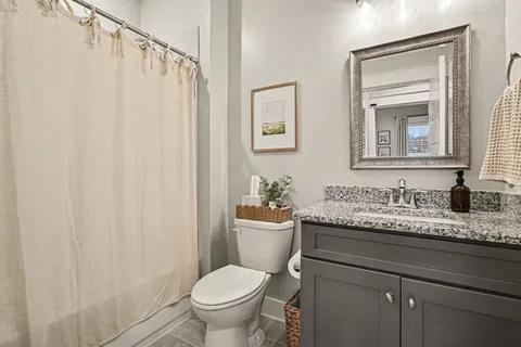 a bathroom with a granite countertop sink toilet and a mirror