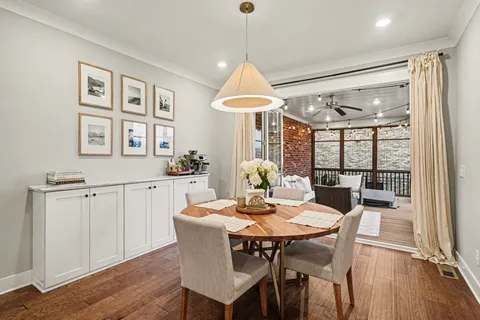 a dining room with furniture a chandelier and wooden floor