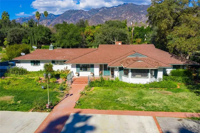 a view of a house with a yard and sitting area