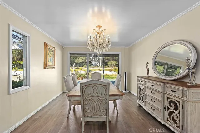 a view of a dining room with furniture a chandelier and wooden floor
