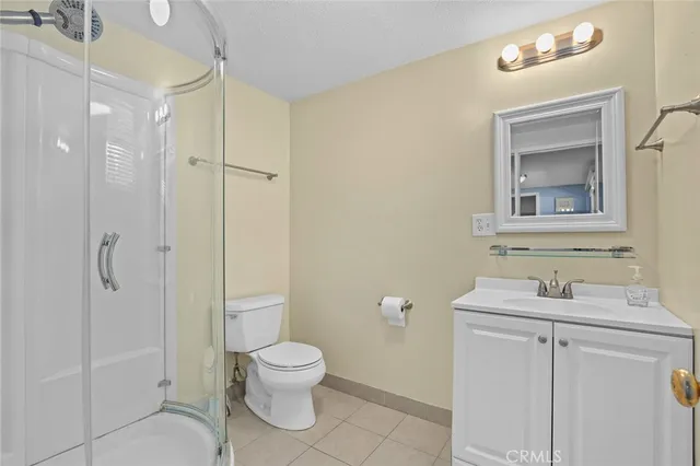 a bathroom with a toilet sink vanity and shower
