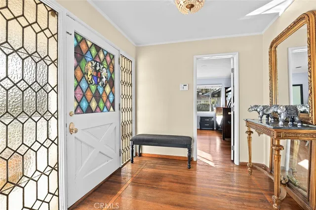 a view of a hallway with wooden floor and furniture