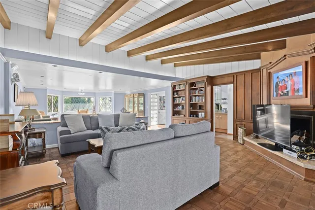 a living room with furniture a flat screen tv and a floor to ceiling window