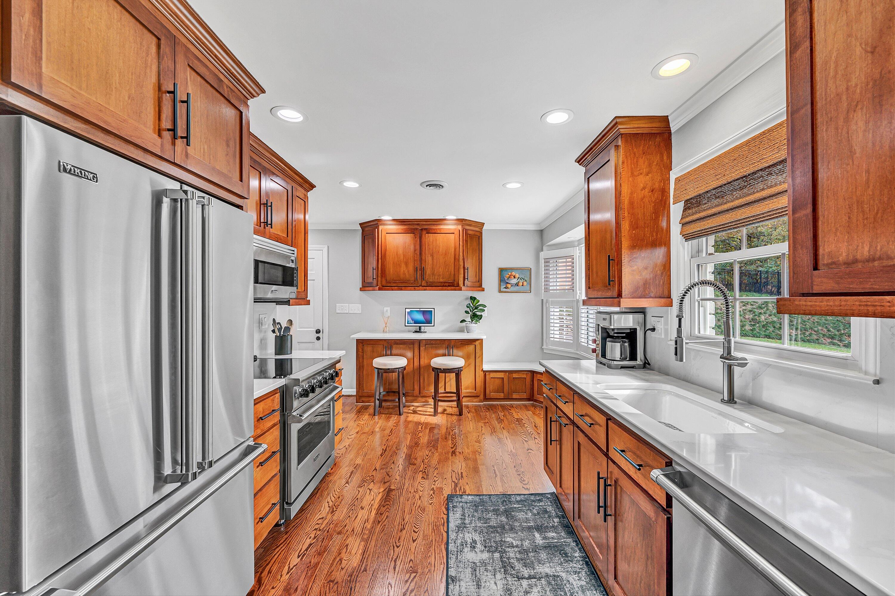 5063 Falcon Ridge Road Roanoke, VA 24018 - Photo 24 of 82 a large kitchen with stainless steel appliances granite countertop a refrigerator a stove a sink a dining table and chairs with wooden floor