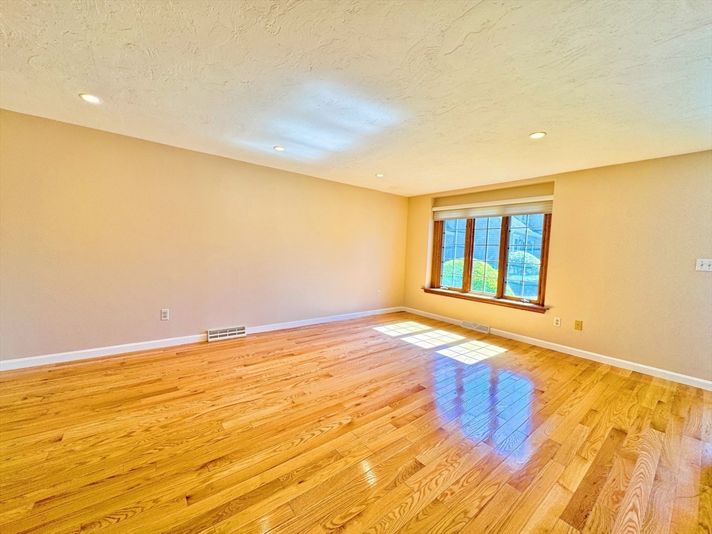7 Washington Green, Unit 7 Walpole, MA 02032 - Photo 3 of 23 a view of an empty room with wooden floor and a window
