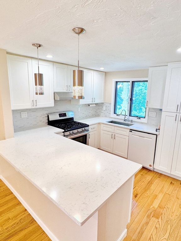 7 Washington Green, Unit 7 Walpole, MA 02032 - Photo 5 of 23 a kitchen with a sink a stove a refrigerator and white cabinets
