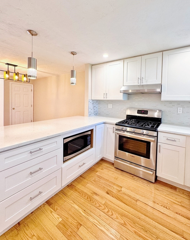 7 Washington Green, Unit 7 Walpole, MA 02032 - Photo 6 of 23 a kitchen with granite countertop wooden cabinets stainless steel appliances and a counter space