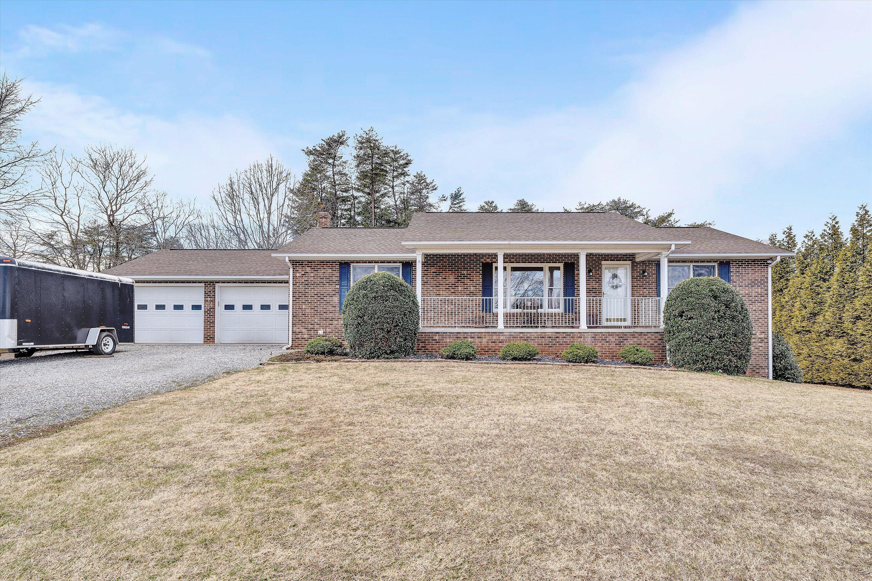 a front view of house with yard and trees in the background