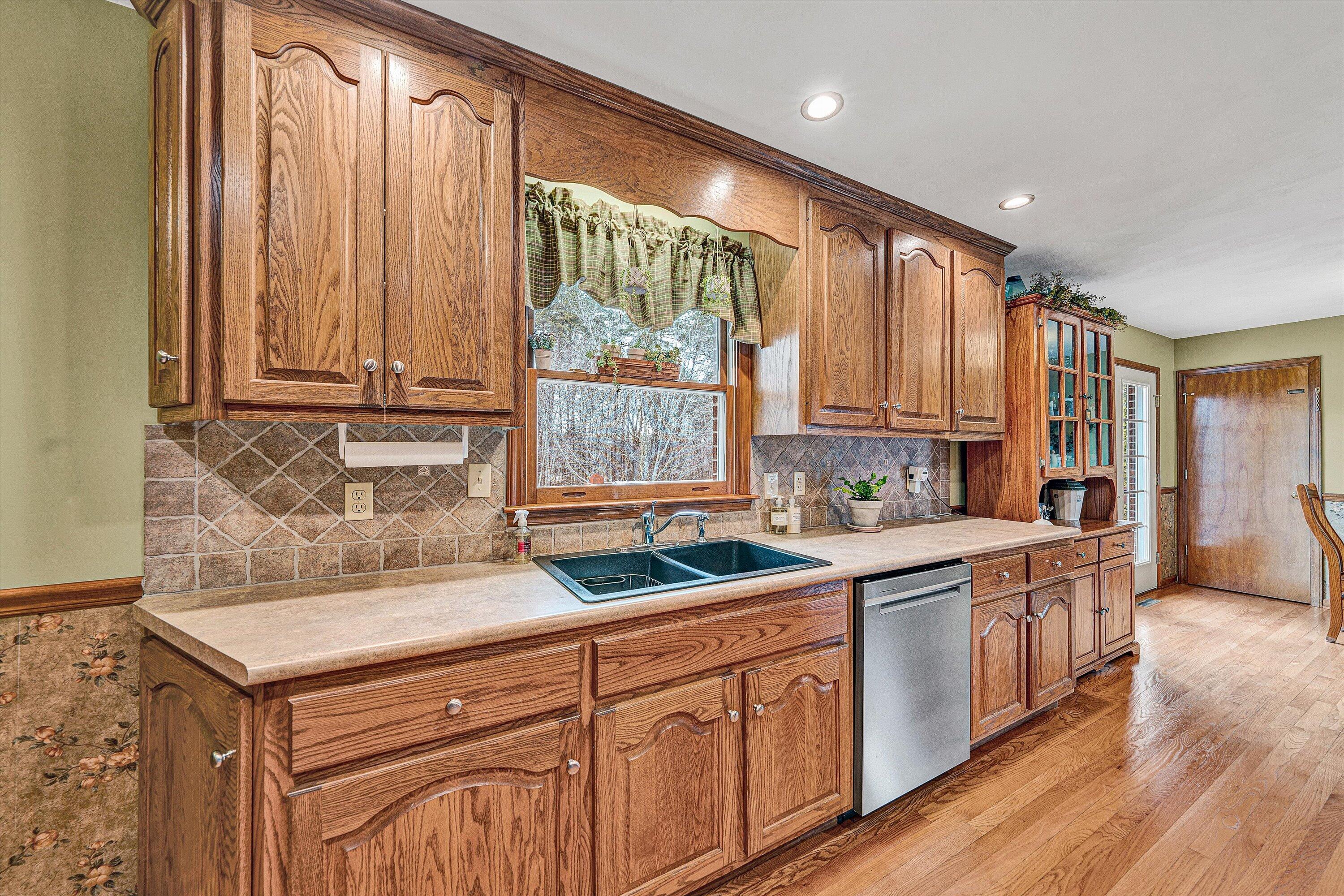 460 Stonybrook Road Wirtz, VA 24184 - Photo 14 of 44 a kitchen with stainless steel appliances granite countertop a sink a stove and cabinets with wooden floor