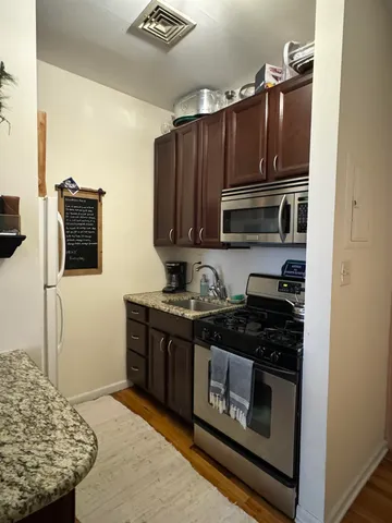 a kitchen with stainless steel appliances granite countertop a stove and a microwave