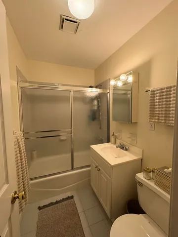 a bathroom with a granite countertop sink toilet a mirror and shower