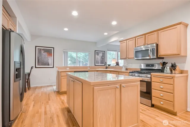 a kitchen with stainless steel appliances granite countertop a stove a sink and a refrigerator