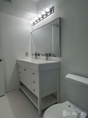 a spacious bathroom with a toilet sink and mirror